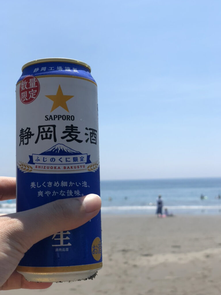 静岡限定のSAPPORO静岡麦酒を海辺で楽しむ様子。夏の伊豆今井浜での滞在イメージ