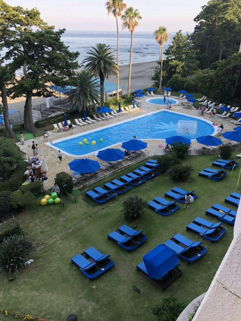 伊豆今井浜東急ホテルの屋外プール。青いパラソルとチェアが並ぶリゾート感あふれる昼の風景