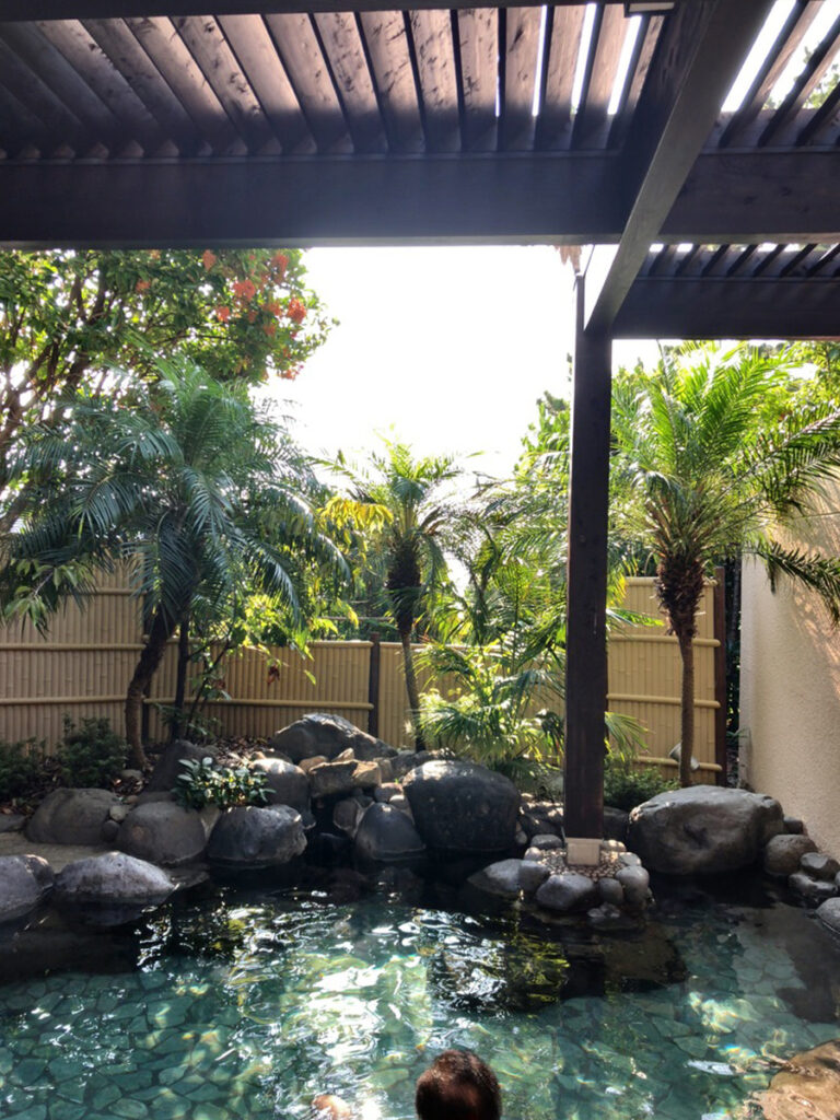 南国風の植栽に囲まれた伊豆今井浜東急ホテルの露天風呂。石造りの湯船と落ち着いた空間
