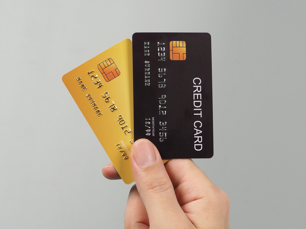 黒と金のクレジットカードを手に持つイメージ。ラボルカード払いを象徴するスピーディーな資金繰り。