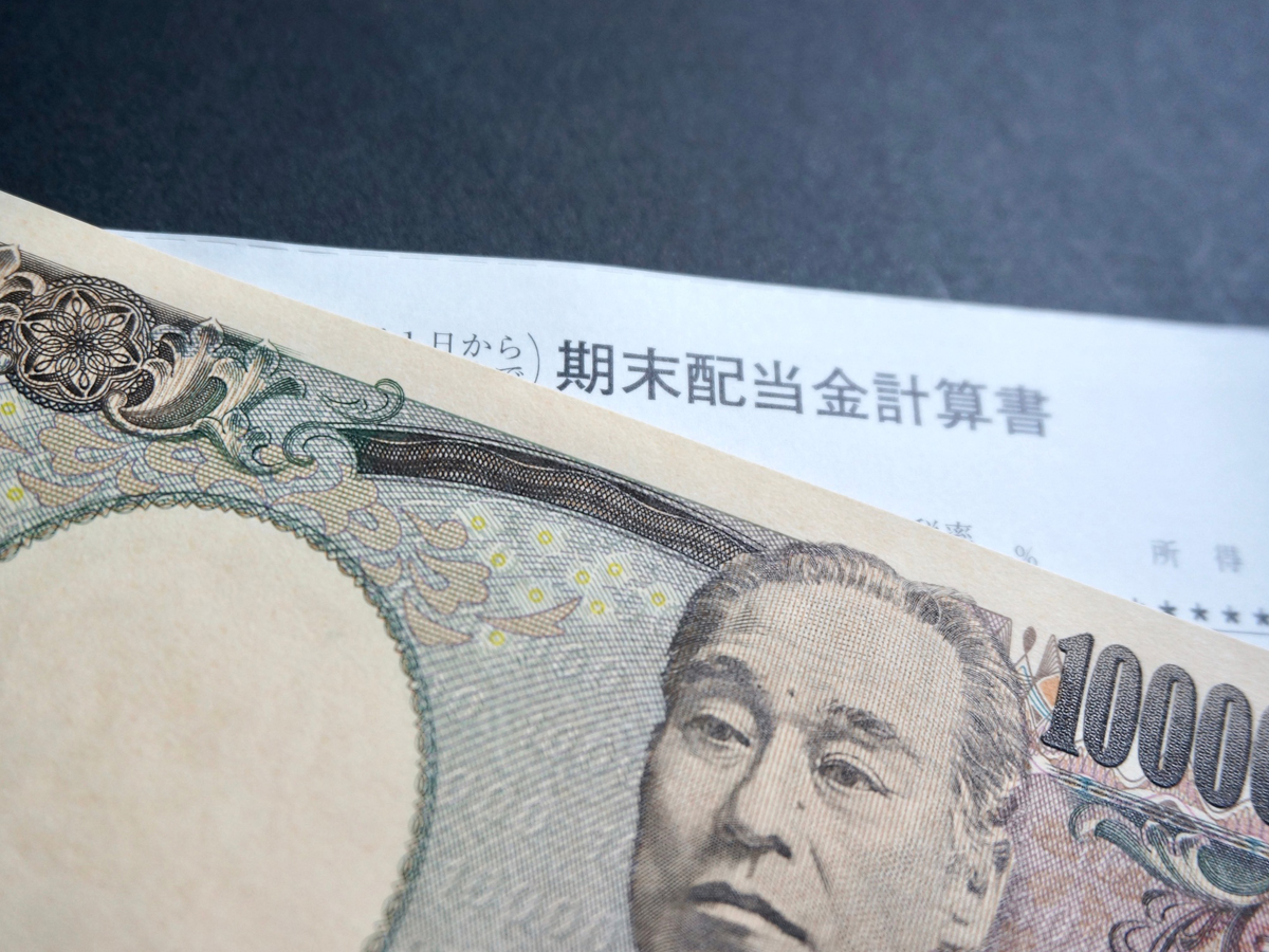 期末配当金計算書と日本円紙幣のクローズアップ（資産形成のイメージ）