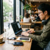ノマドワーカーがカフェでモバイルWiFiを使って仕事をしている様子