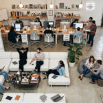 開放的なコワーキングスペースで複数のビジネスパーソンがノートPCで作業している様子