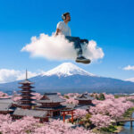 Digital nomad working on a laptop in Japan with a city skyline, highlighting a productive stay setup for foreign visitors