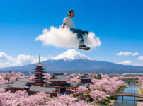 Digital nomad working on a laptop in Japan with a city skyline, highlighting a productive stay setup for foreign visitors