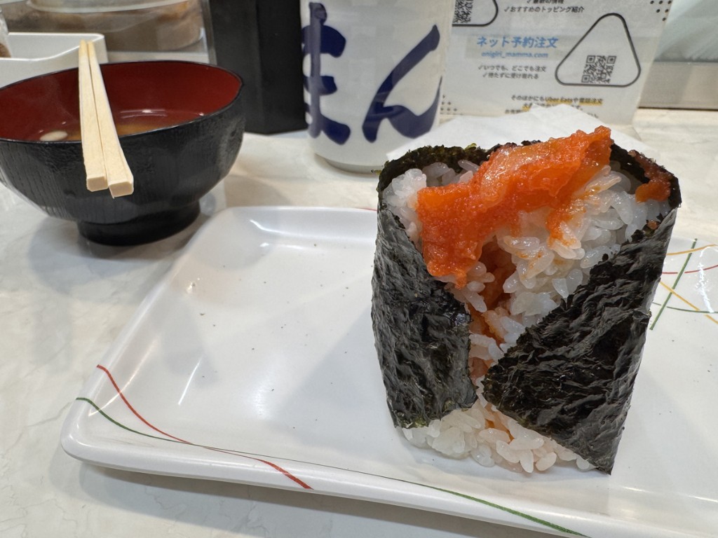 Large onigiri with mentaiko filling, miso soup, and tea at a Japanese counter-style eatery
