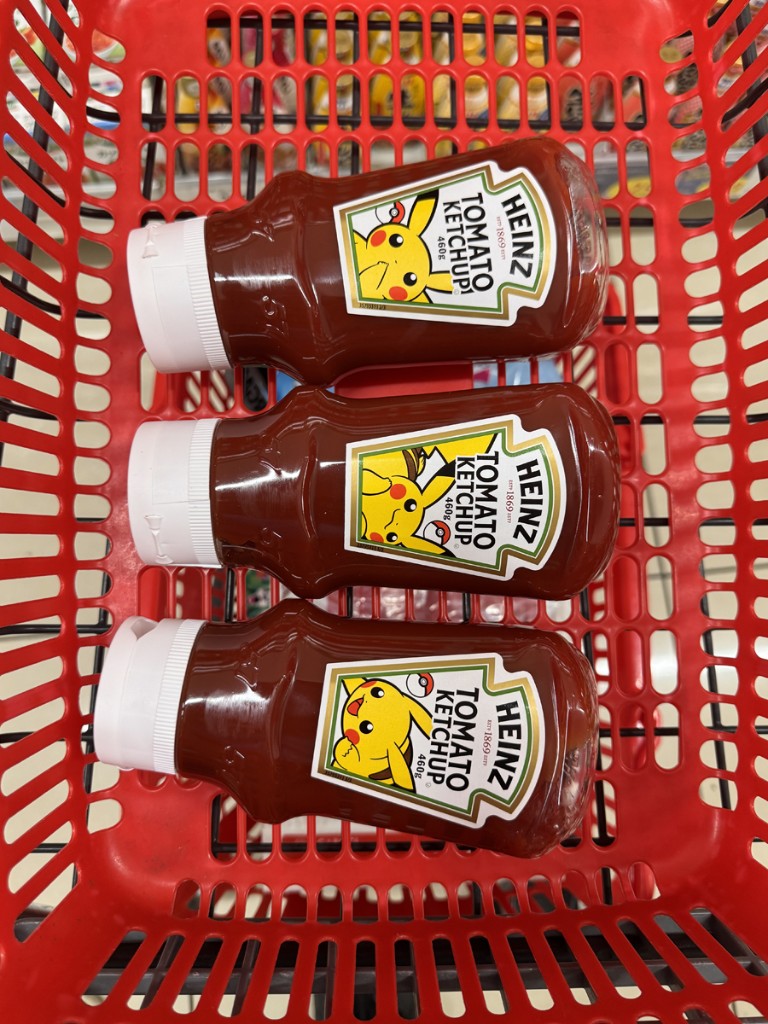 Three Heinz ketchup bottles with Pikachu special labels in a red supermarket shopping basket