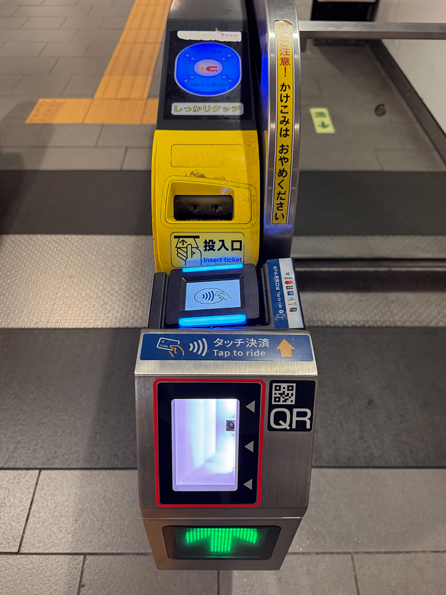 Top-down view of a Japan train ticket gate showing IC reader, paper ticket slot, Tap to ride contactless module, and QR area